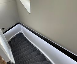 De moderne strakke trapleuning met RGBW LED-verlichting geplaatst